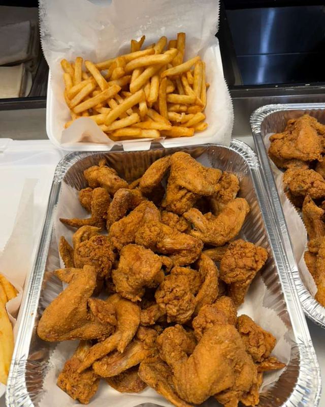 A pan of fried chicken with a box of fries