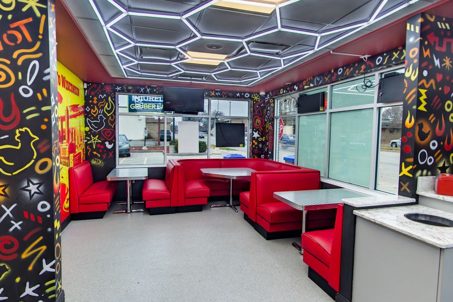 Red booths and the art wall under the honeycomb ceiling
