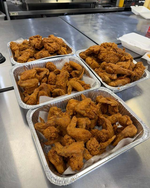 Four pans of fried wings ready for a party order