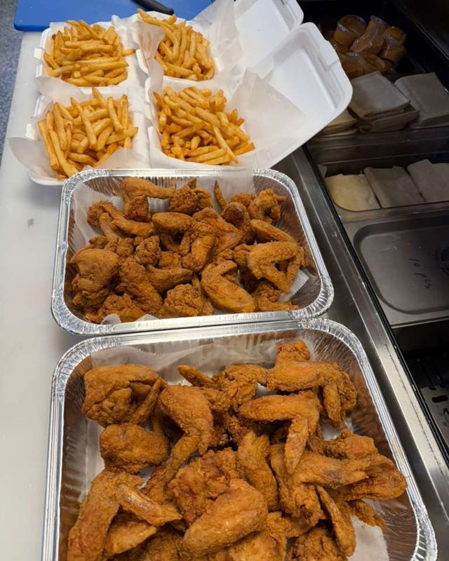 Pans of wings with boxes of fries